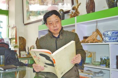 李麒在自己的书画室研读书籍